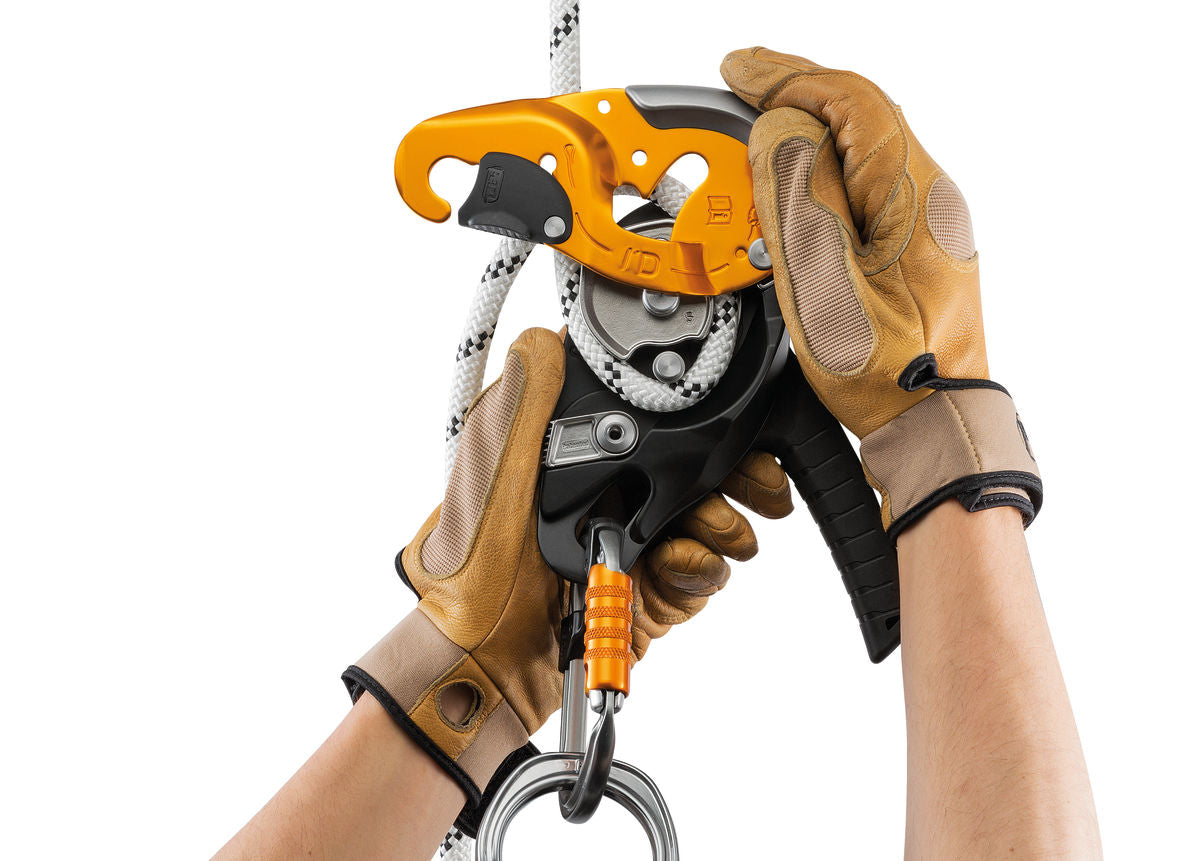 The Petzl I'D S being attached to a white climbing rope